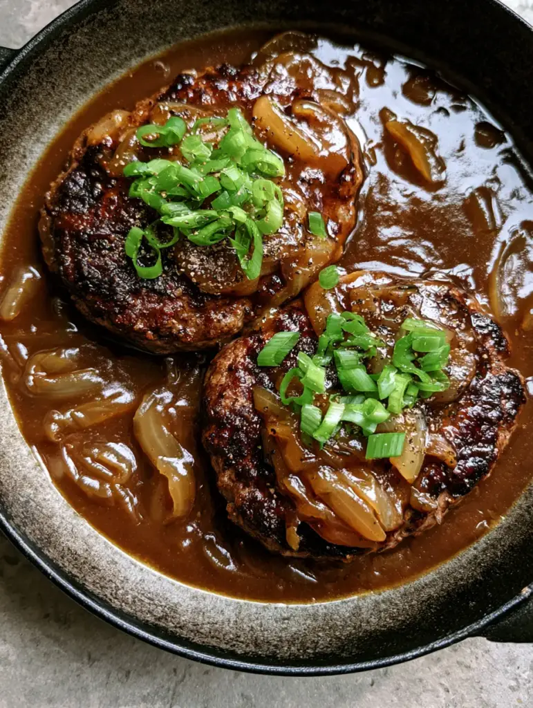 Glossy umber brown gravy with translucent onion slivers covering beef steaks in a cast iron pan.